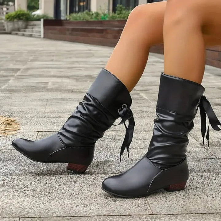 Black slouchy lace-up block heel mid-calf boots walking, side view close-up