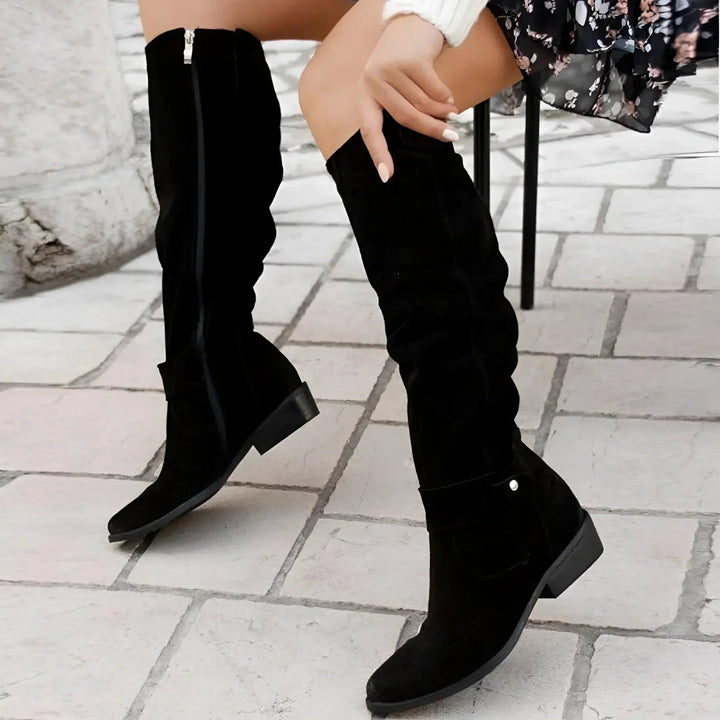 Anneliese knee high boots styled with animal print dress on stone steps