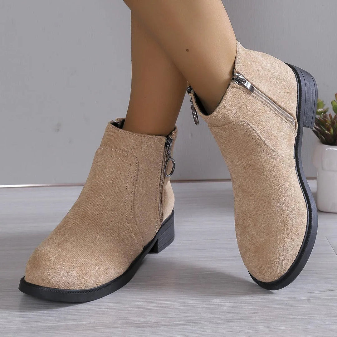Bettina tan suede ankle boots with side zipper, crossed leg view