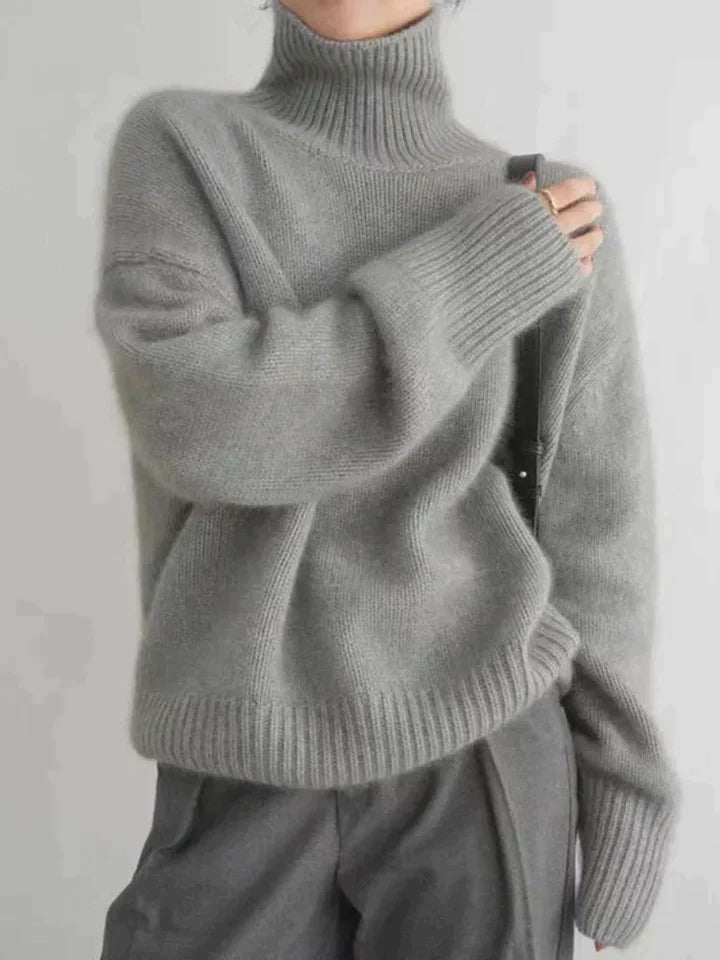 Camille turtleneck sweater with hand raised to collar, side view