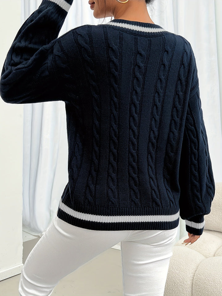 Back view of navy cable-knit sweater showing striped hem and cuff trim