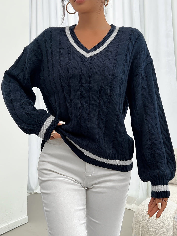 Close-up of navy cable-knit V-neck sweater sleeve and striped cuff detail