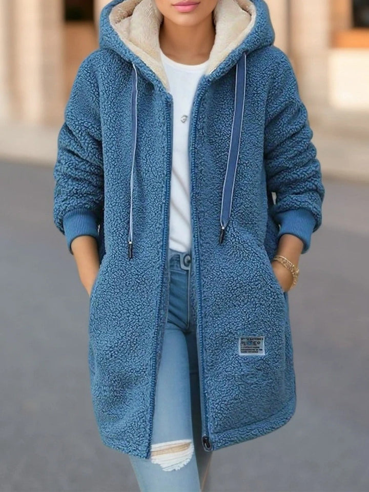 Fenella hooded teddy coat in blue, front view with hood up and hands in pockets