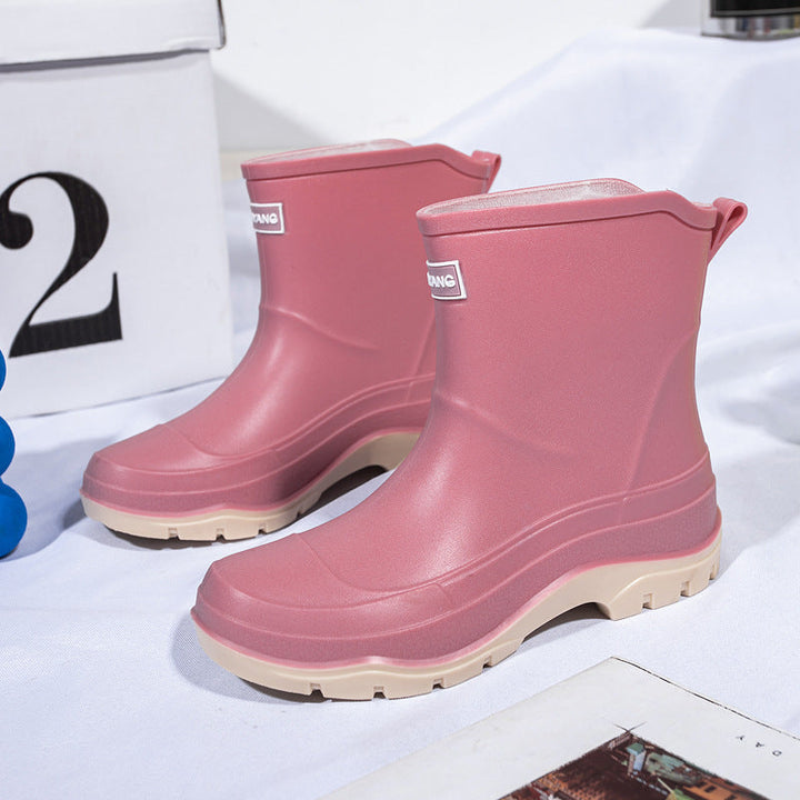 Genevieve black rain boots with neon green contrast sole, front view