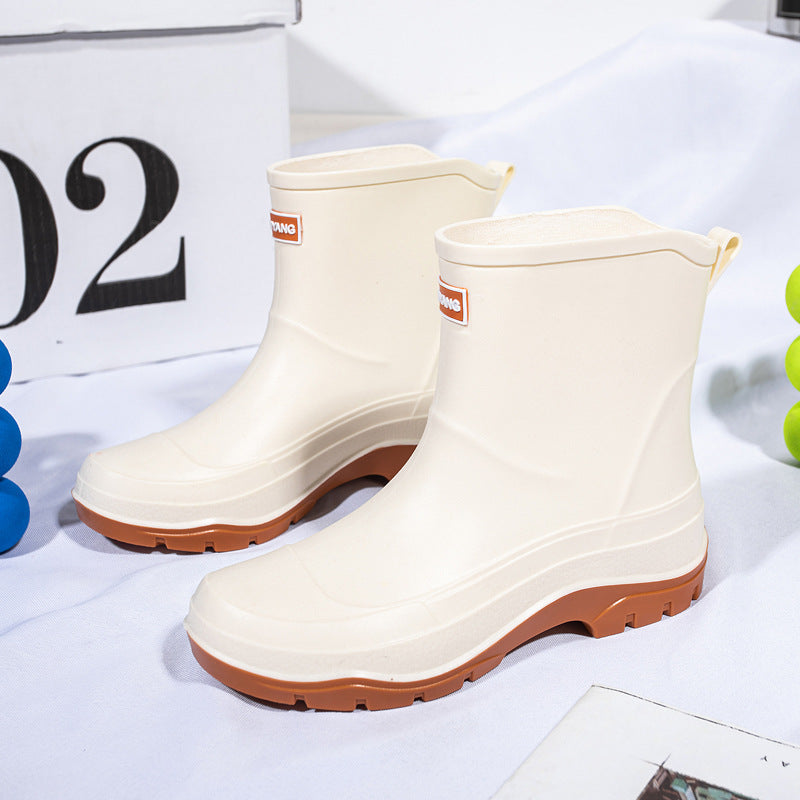 Genevieve black rain boots with neon green contrast sole, front view