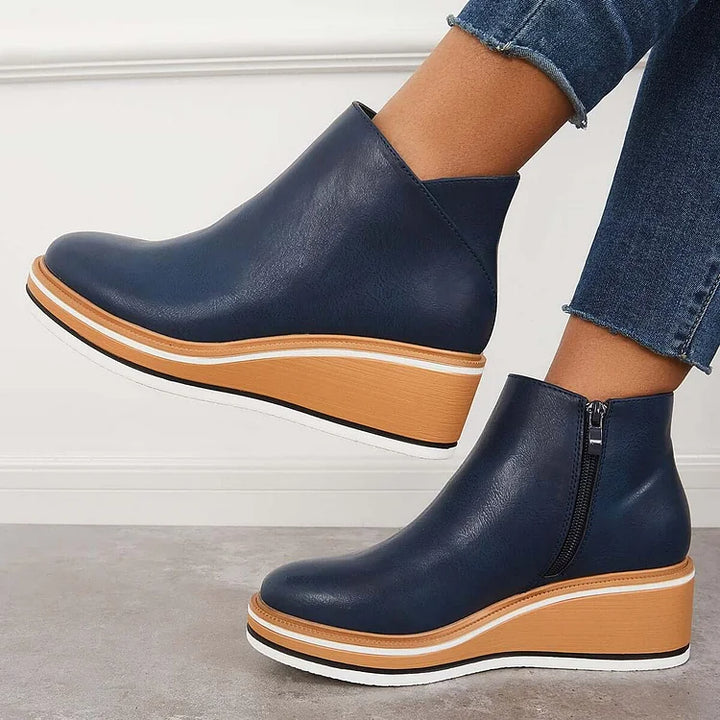 Harlow navy wedge boots worn with jeans, side profile
