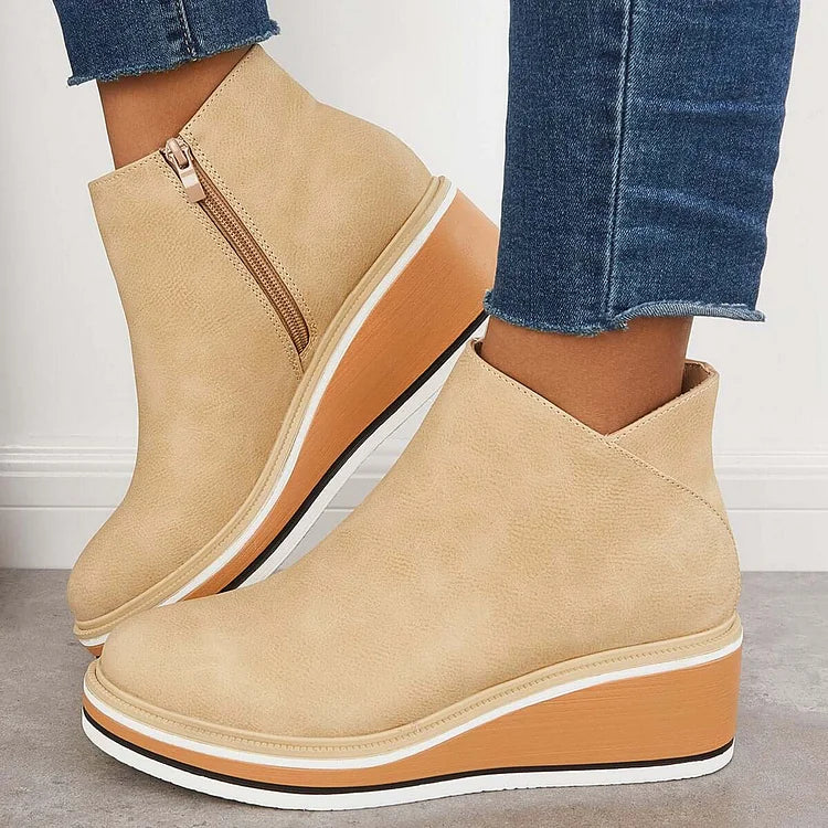 Harlow beige wedge ankle boots worn with jeans, side view