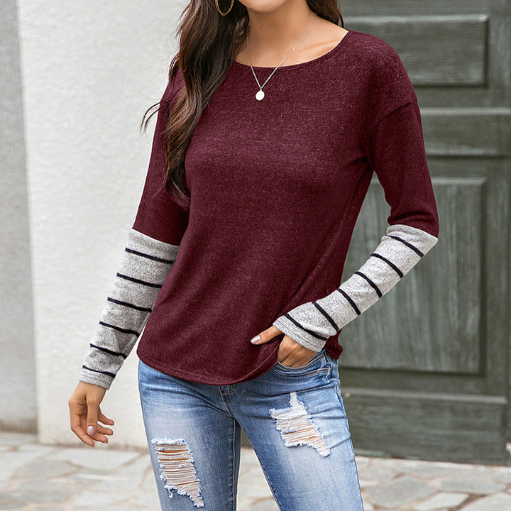 Harlow striped cuff long sleeve top in burgundy, front view against wooden door