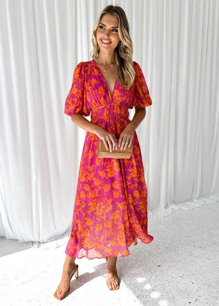 Isa floral maxi dress with puff sleeves, front view holding clutch
