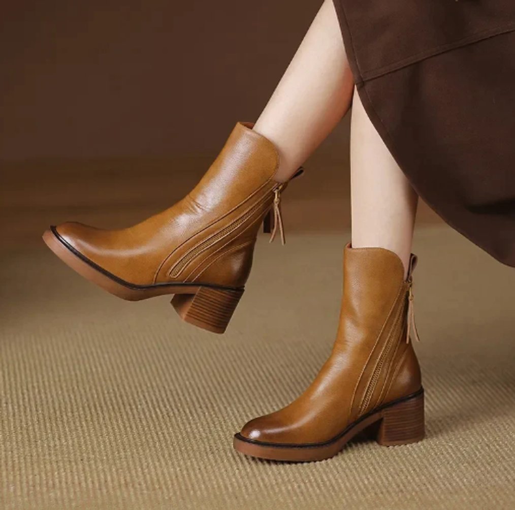 Juniper leather block heel ankle boots worn while walking, side view
