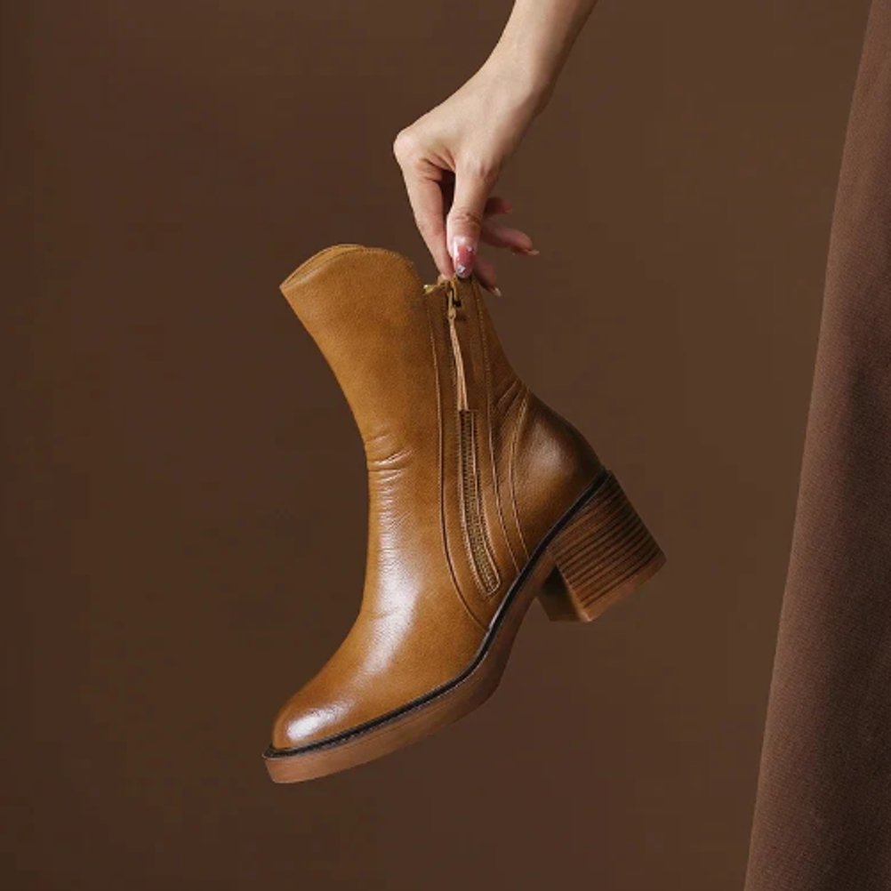 Juniper ankle boot held by hand showing side zip and block heel detail