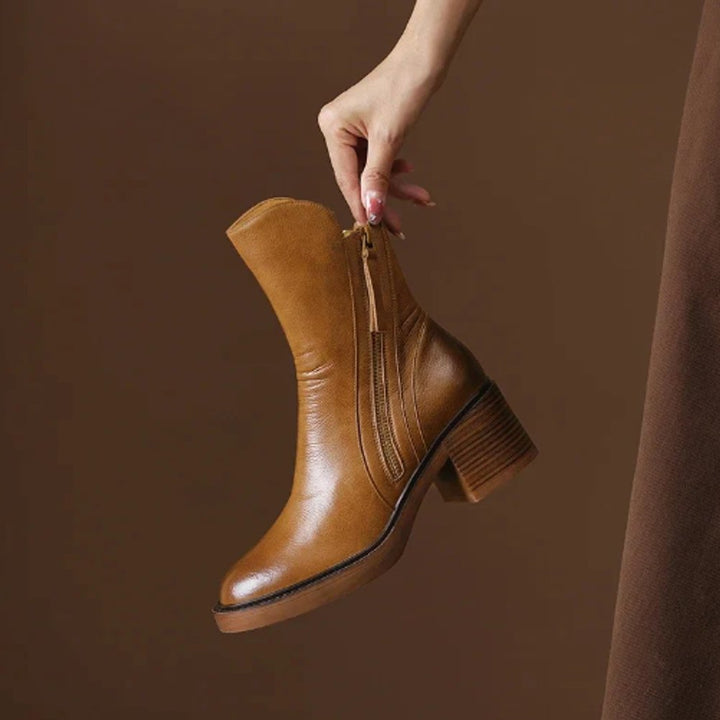 Juniper ankle boot held by hand showing side zip and block heel detail