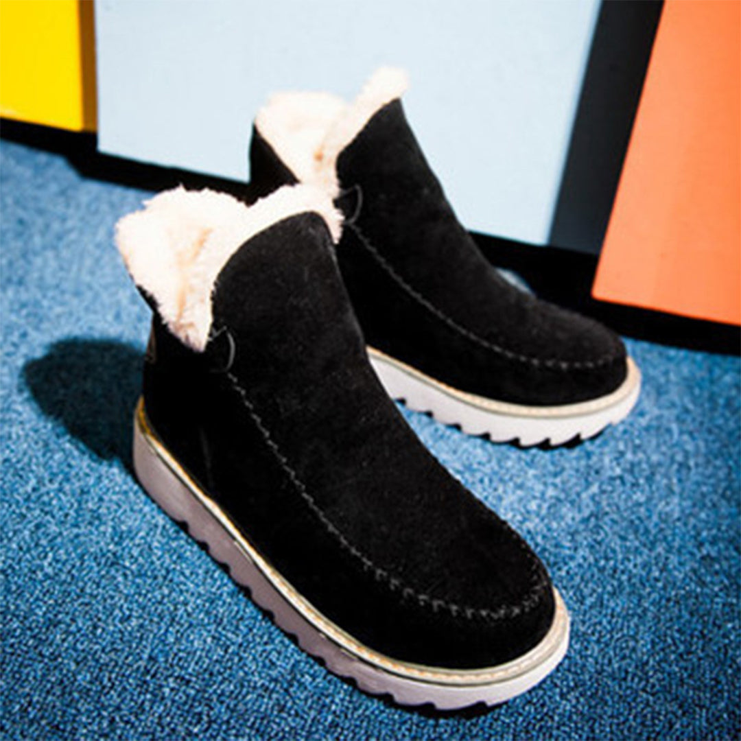 Marigold ankle boots with stitched detail on colorful floor