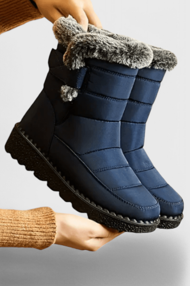 Marlowe waterproof winter boot in navy with faux fur trim, side view held by hand
