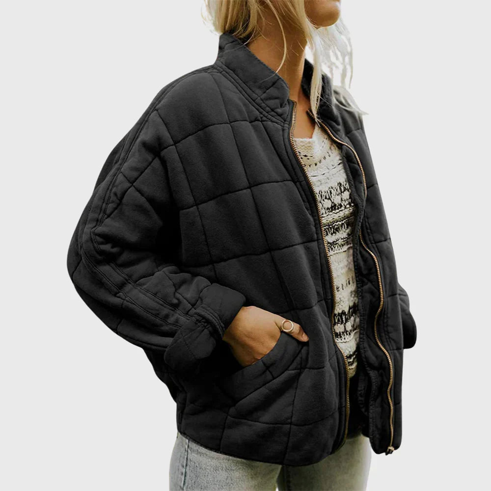 Marlowe quilted zip-up bomber jacket in black, front side view with hand in pocket