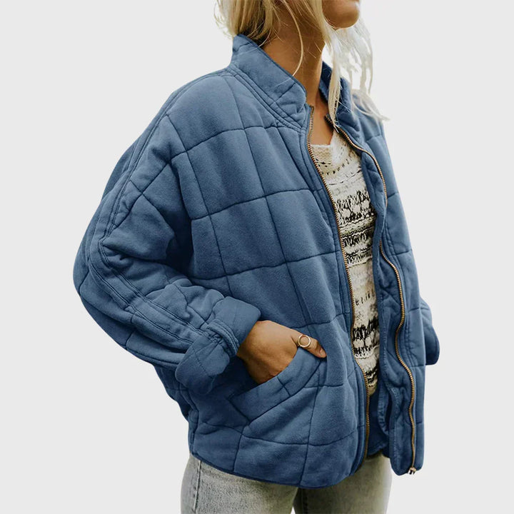 Marlowe quilted zip-up bomber jacket in blue, front side view with hand in pocket