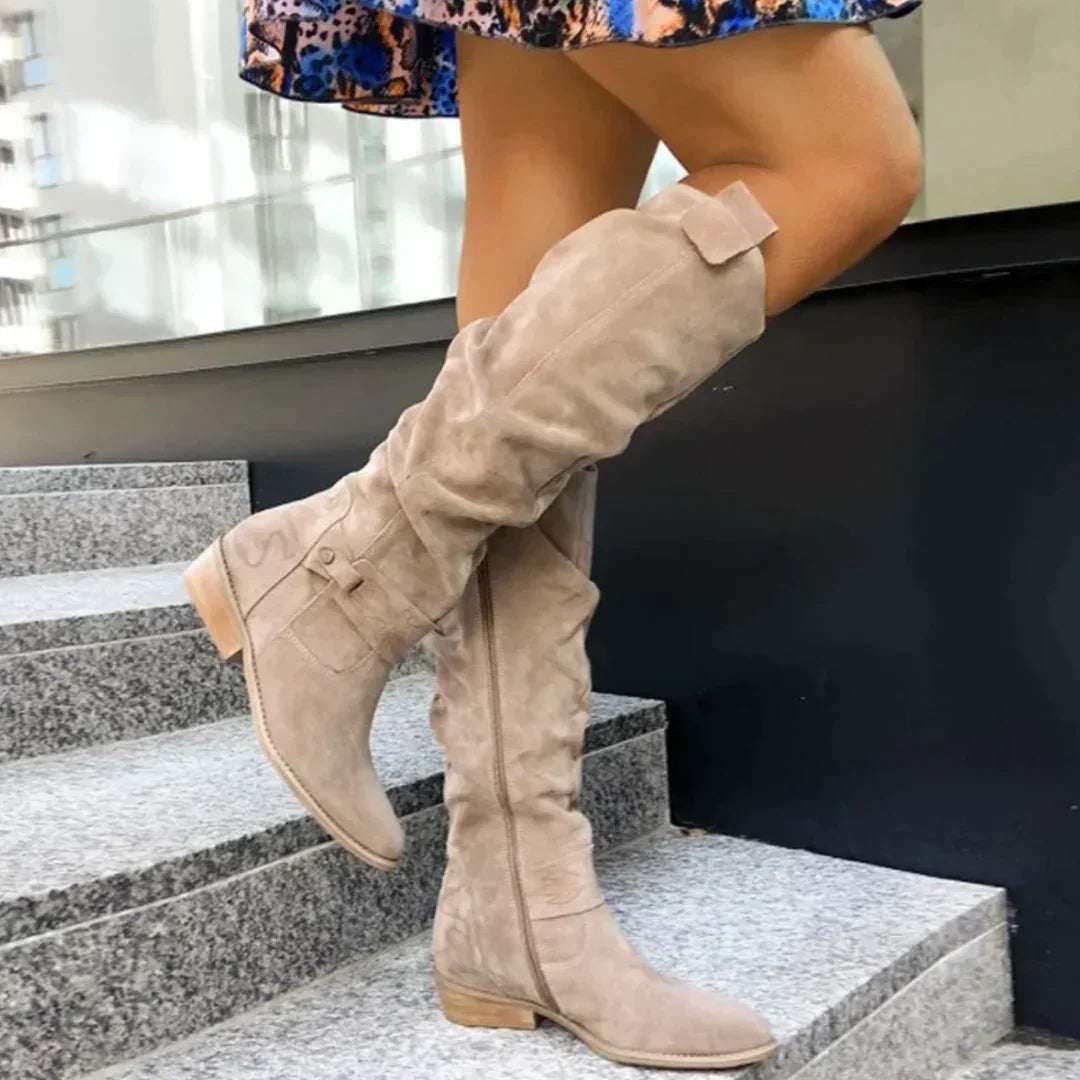 Odessa slouchy knee high boots with buckle strap, side view on stairs