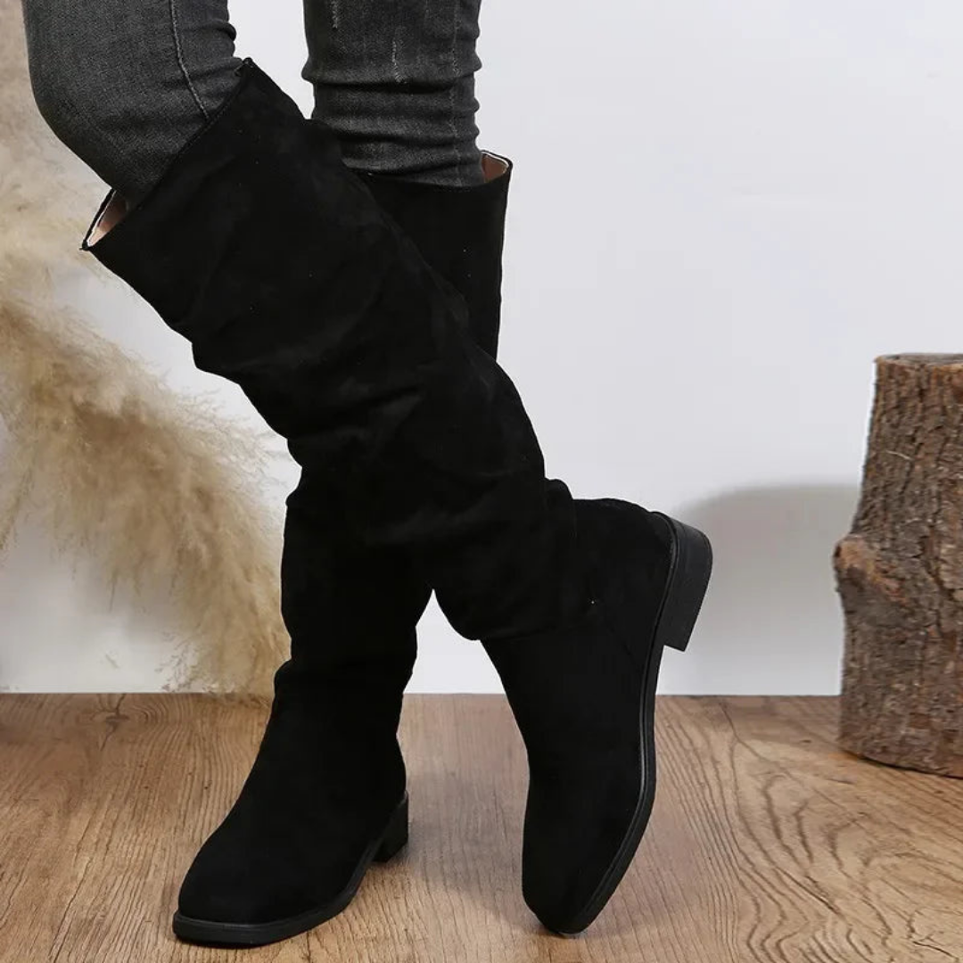 Rosalind slouchy knee high flat boots in black, walking side view