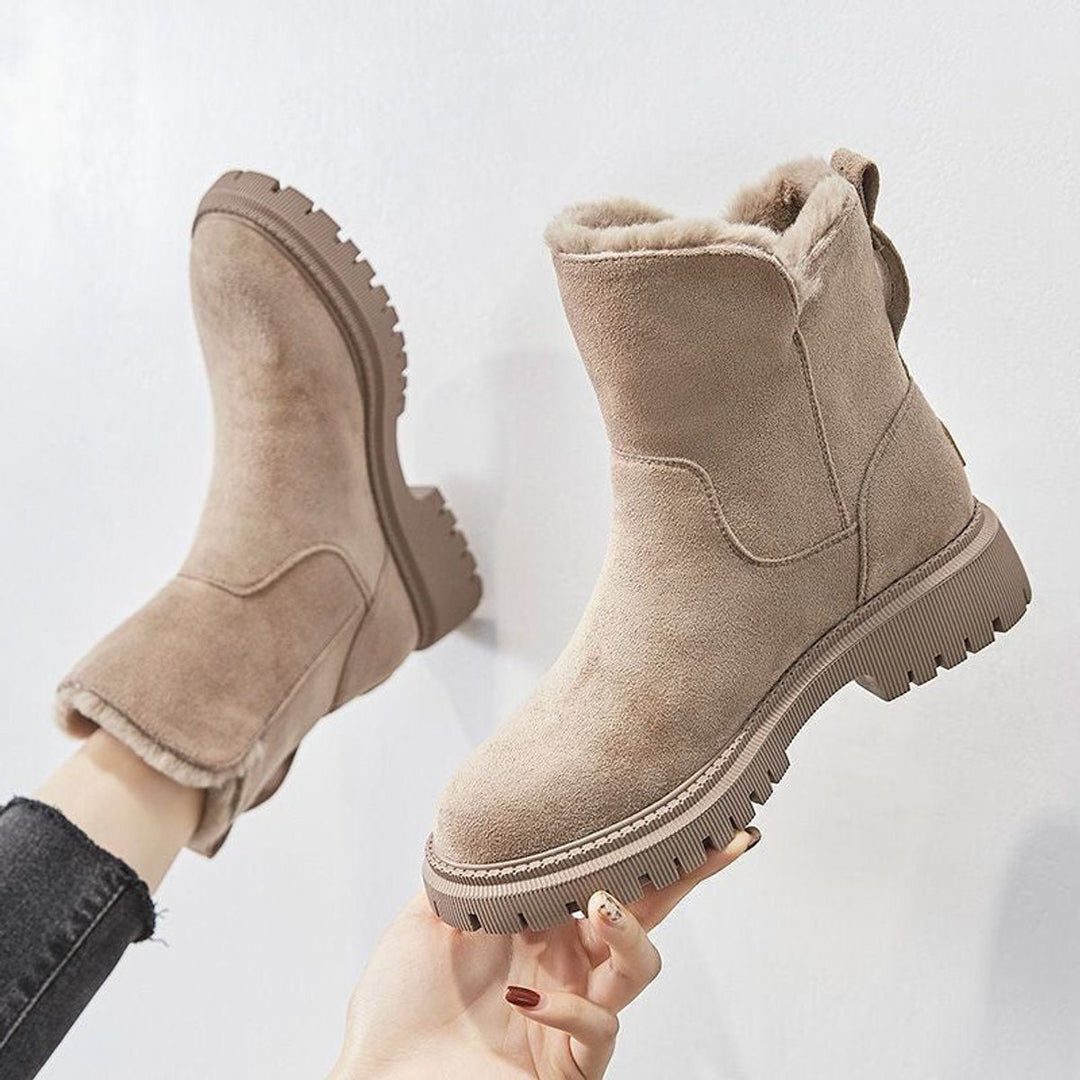 Rosalyn fur-lined slip-on ankle boots held up by hand, side view showing platform sole