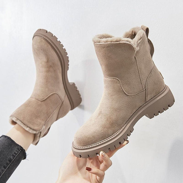 Rosalyn fur-lined slip-on ankle boots held up by hand, side view showing platform sole
