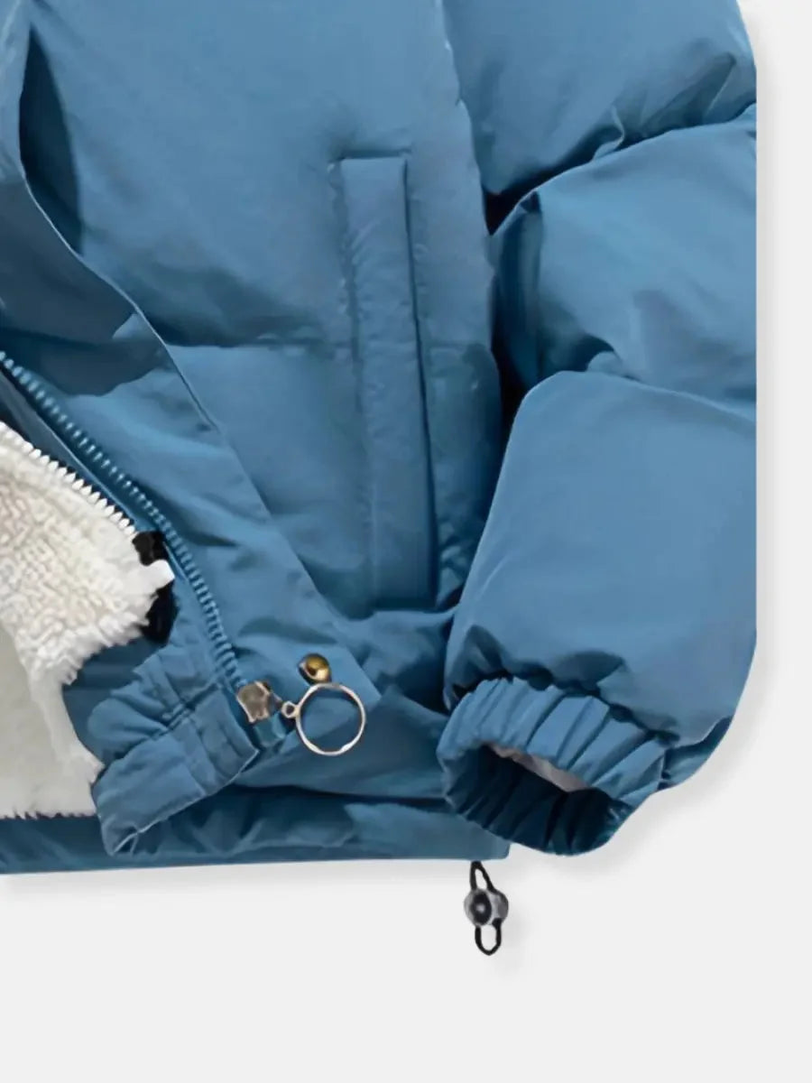 Close-up of blue puffer jacket cuff and zipper pull detail