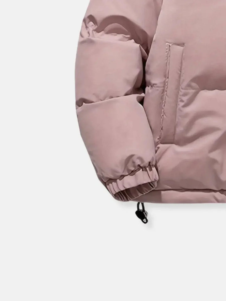 Close-up of pink puffer jacket cuff and side pocket detail