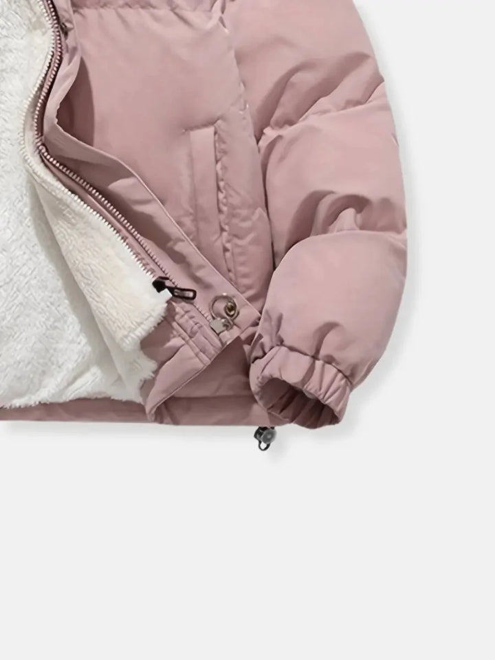 Close-up of pink puffer jacket zipper and fleece lining interior