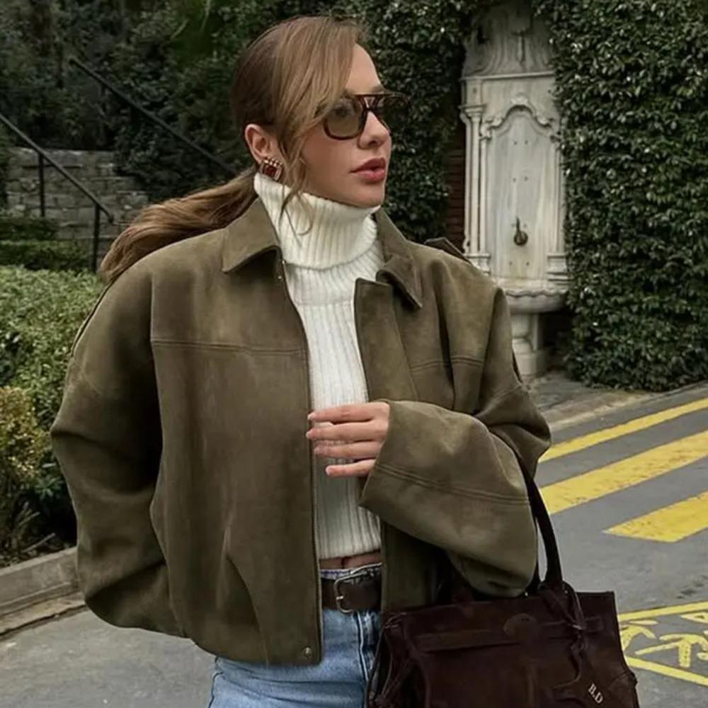 Woman wearing Talia oversized bomber jacket over a turtleneck sweater and jeans