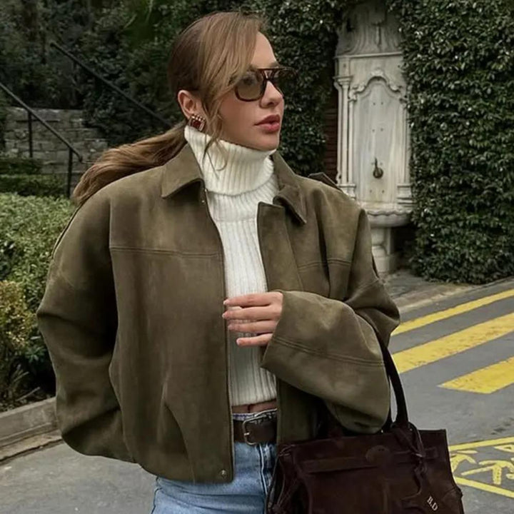 Woman wearing Talia oversized bomber jacket over a turtleneck sweater and jeans
