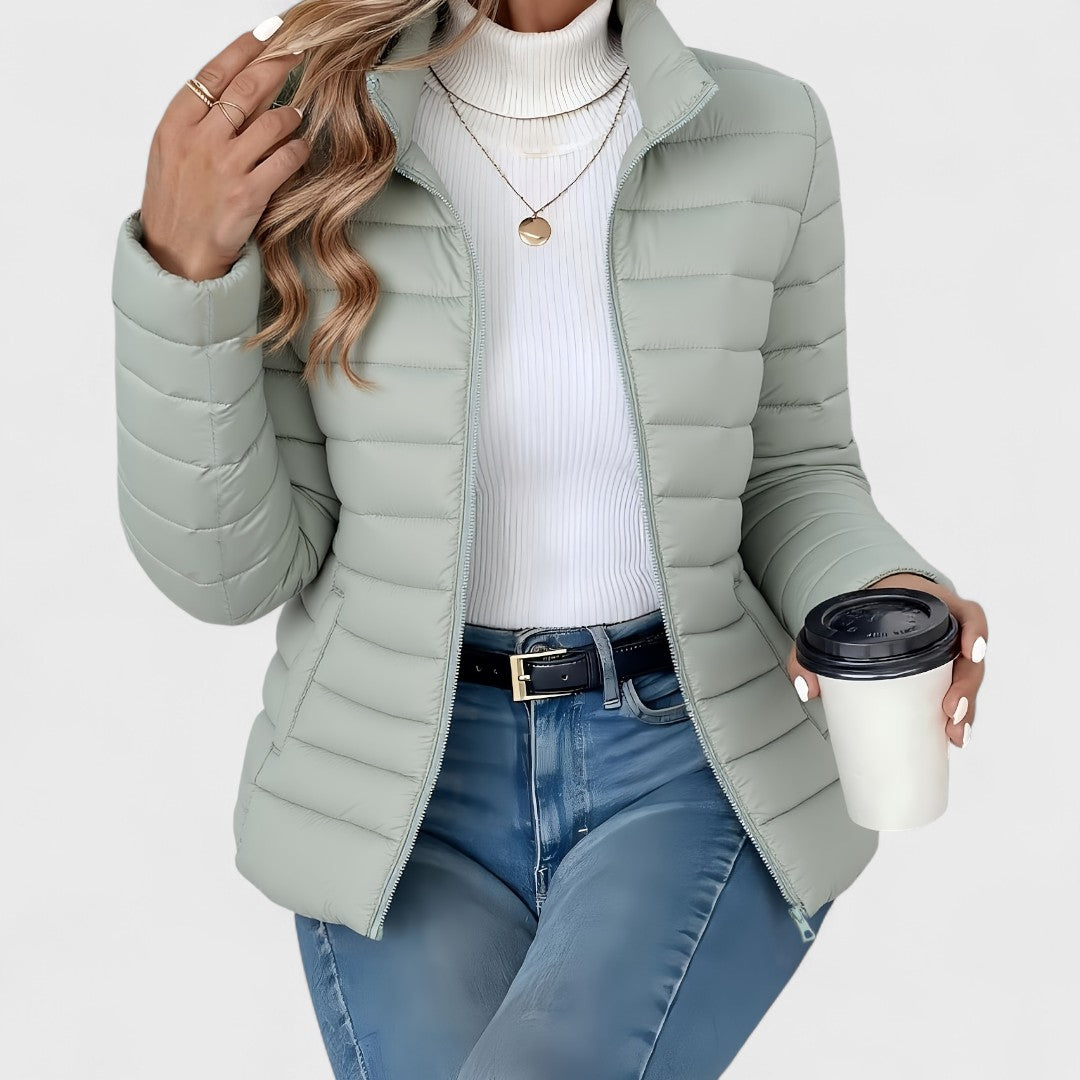 Vienna quilted puffer jacket in sage green, front view with model holding coffee