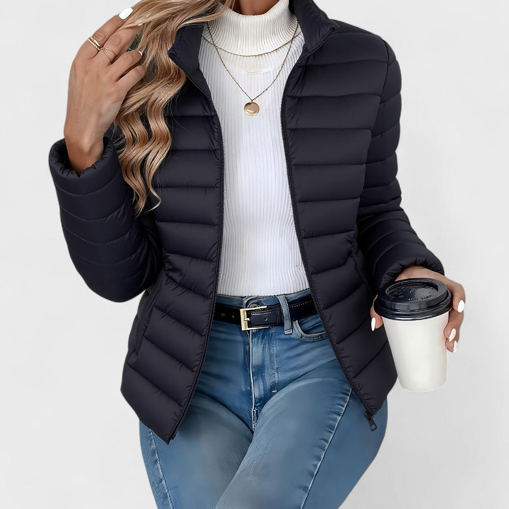 Vienna quilted puffer jacket in black, front view with model holding coffee