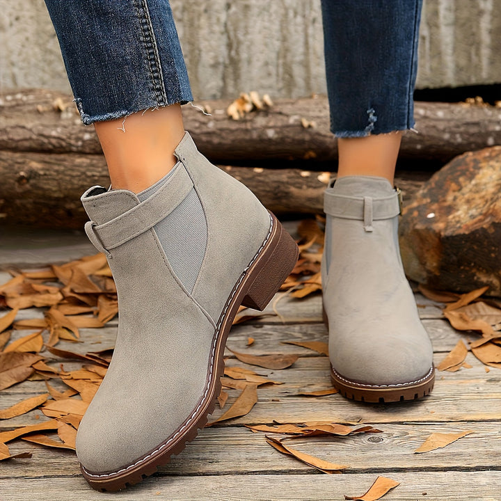 Gray Vivienne Chelsea boots worn on model, back view showing buckle