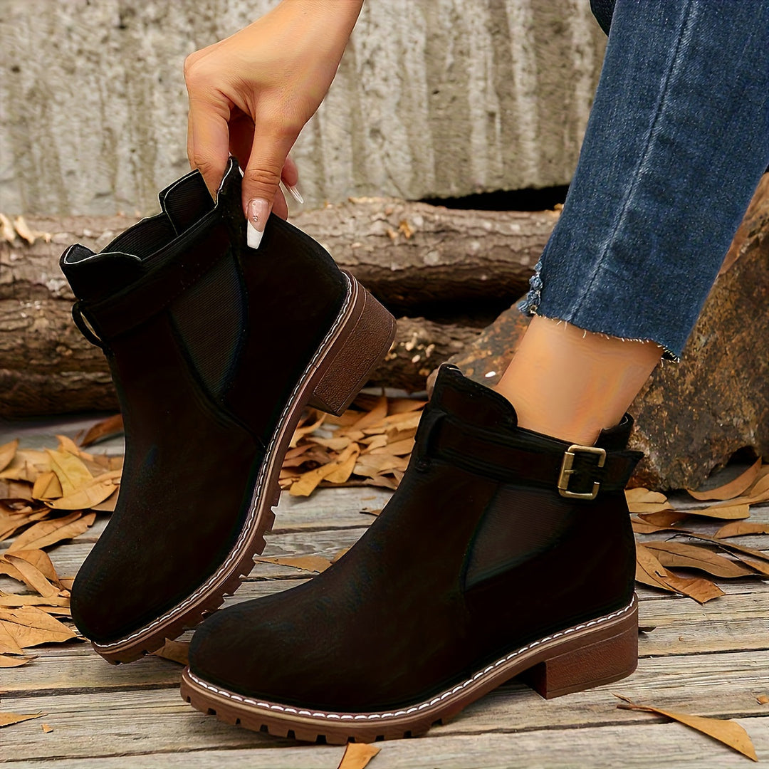 Close-up side view of black Vivienne Chelsea boot with buckle strap
