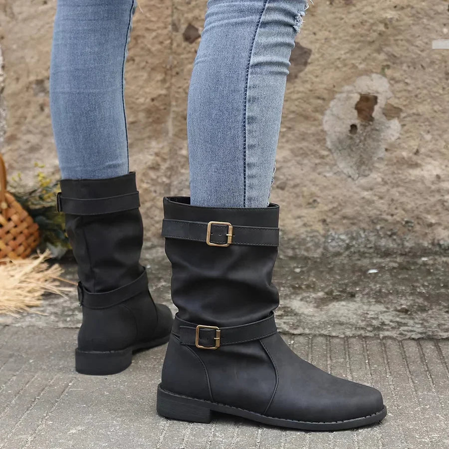 Wilhelmina buckle strap western boots worn while walking, side profile