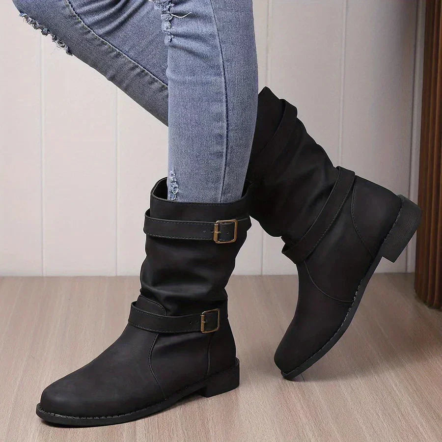 Wilhelmina buckle strap western boots worn while walking, side profile