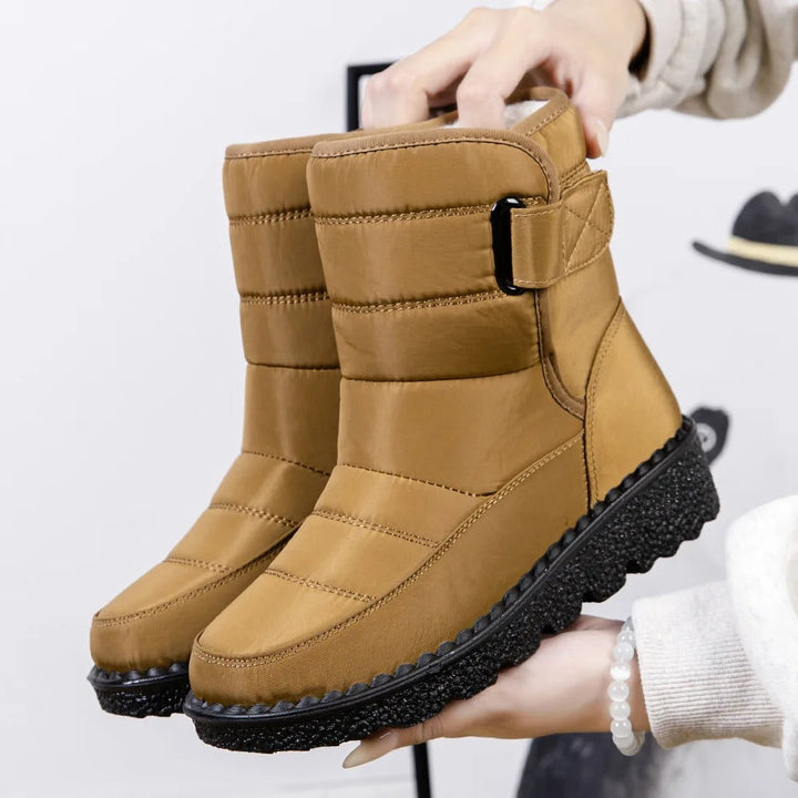 Winifred waterproof mid-calf snow boots in tan, held up by hand, side view