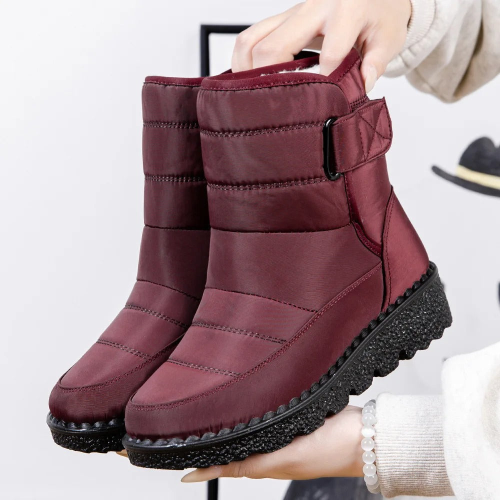 Winifred waterproof mid-calf snow boots in burgundy, held up by hand, side view