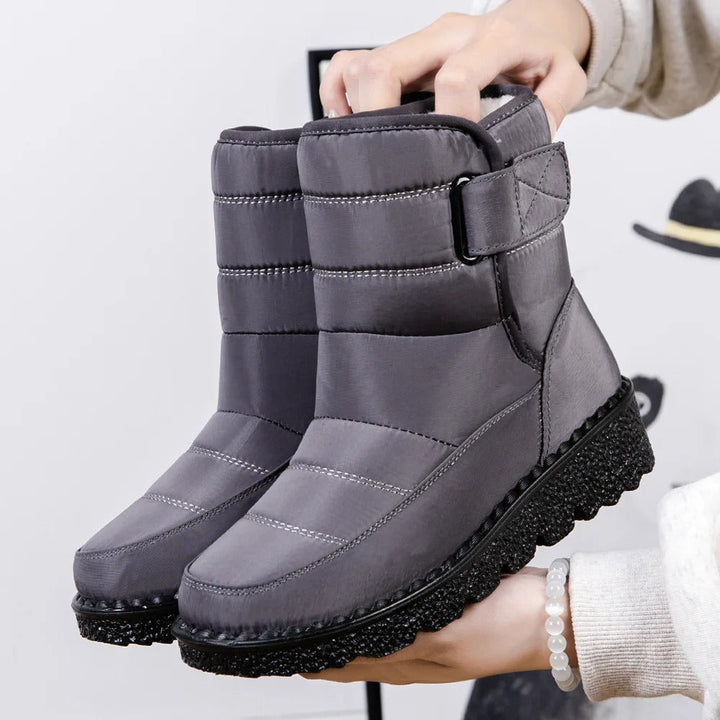 Winifred waterproof mid-calf snow boots in gray, held up by hand, side view