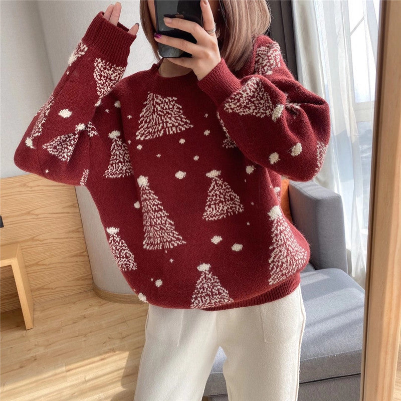 Rosamund Christmas tree print sweater in burgundy, front view with phone in hand