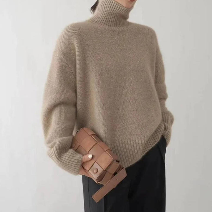 Rosalind turtleneck sweater paired with woven handbag