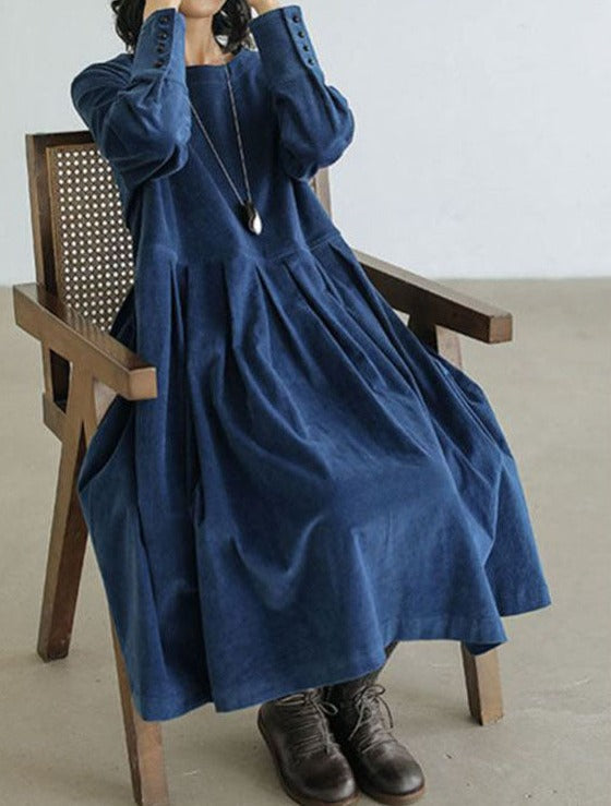 Odessa pleated midi dress in blue, seated side view