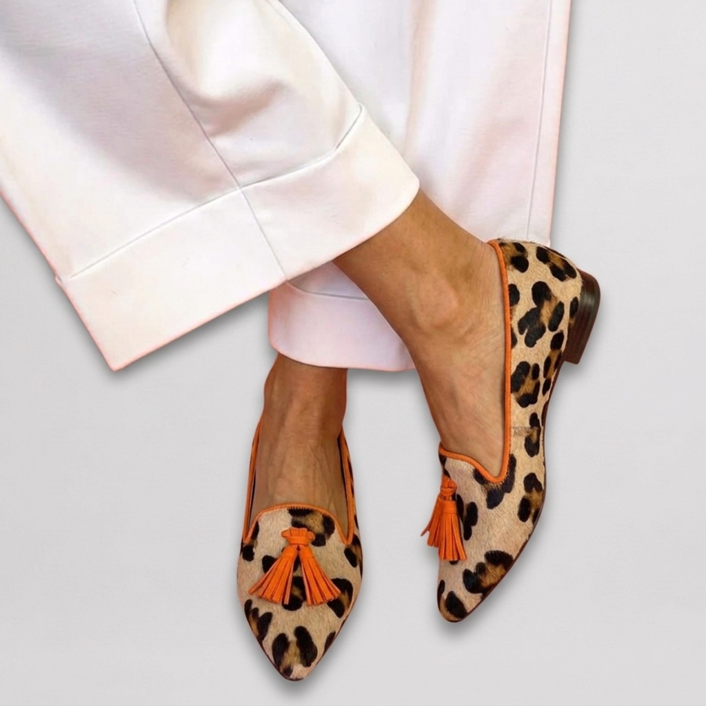 Marisol leopard print pointed toe loafers with orange tassel detail, close-up front view