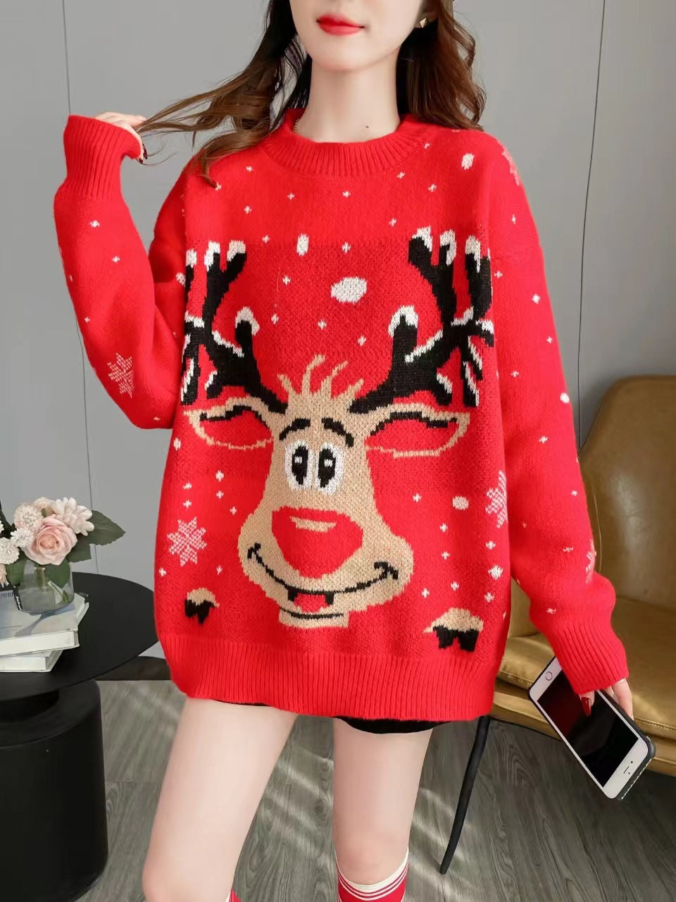 Clementine reindeer Christmas sweater, front view with phone in hand