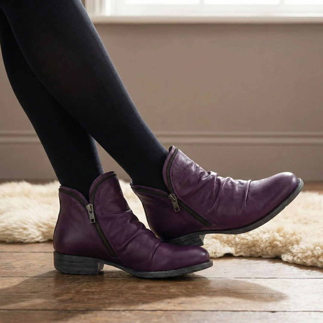 Vivienne purple slouch ankle boots with side zip, worn crossed at the ankles