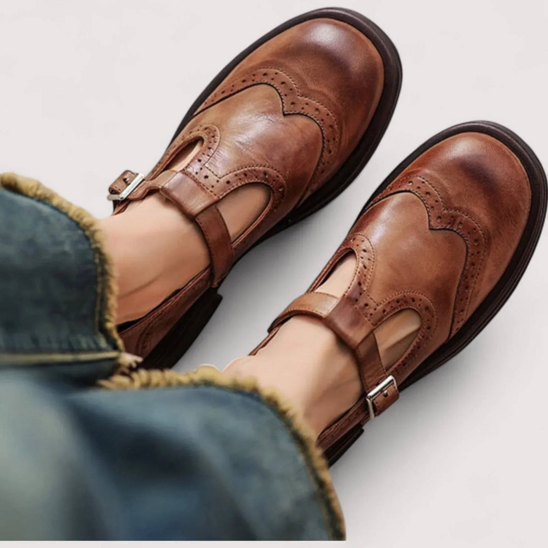Thea wingtip T-strap Mary Jane shoes in brown, top-down view on model