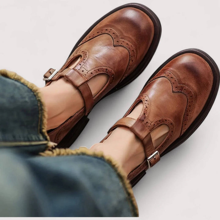 Thea wingtip T-strap Mary Jane shoes in brown, top-down view on model