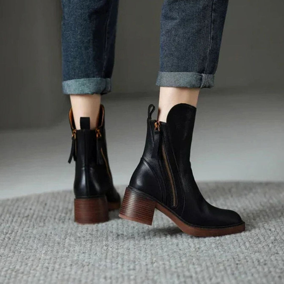 Marguerite black ankle boots worn on feet, walking view