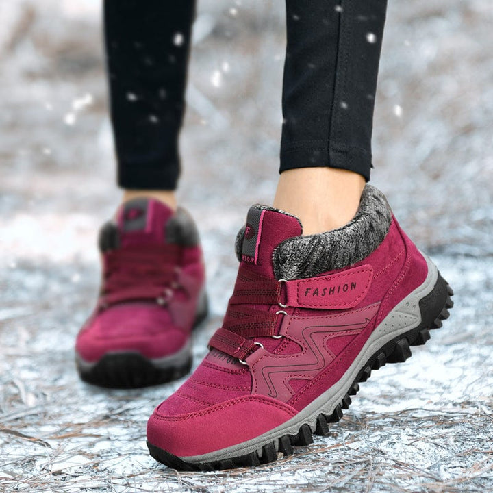 Wren fur trim winter ankle boots in burgundy, worn outdoors in snow