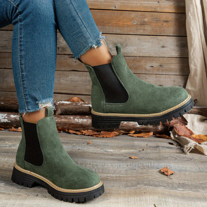 Wynter Chelsea boots in green, side view on model